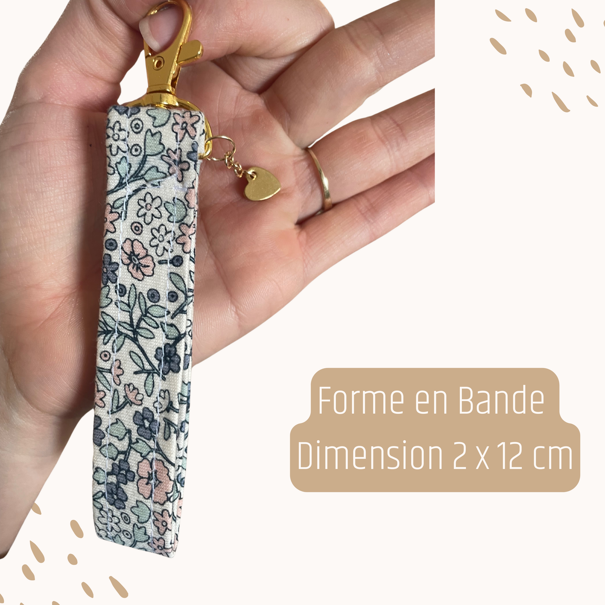 Zoom sur un porte-clés souvenir Petit Chêne, forme bande, tenu dans une main. Accessoire fait main en France à partir de vêtements souvenirs.
