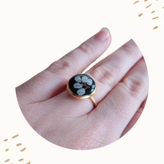 Bague souvenir Petit Chêne en acier inoxydable argenté, décorée d’un fragment de tissu scellé sous la résine. Création artisanale réalisée à la main en Haute-Vienne.